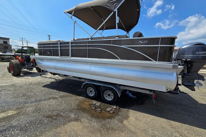 The Image of 2024 Bennington S22 pontoon boat on trailer with Yamaha outboard motor. - 0