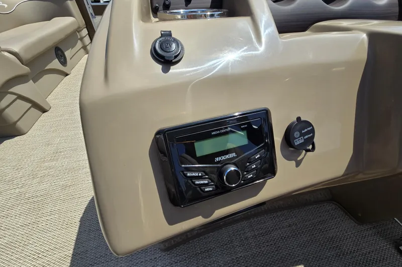 Slide: The Image of 2024 Bennington S22 boat dashboard with Kicker media center and USB charging port. - 24