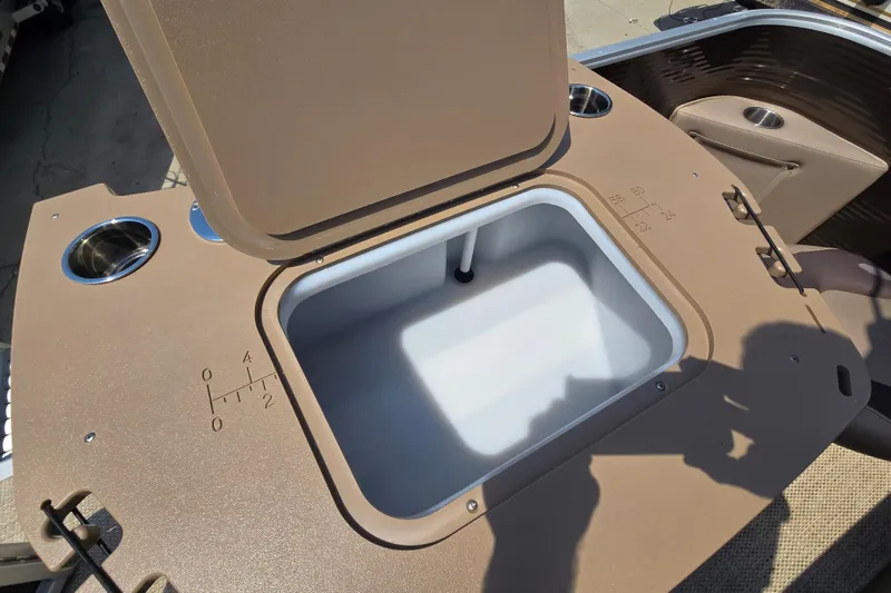 Slide: The Image of 2024 Bennington S22 boat storage compartment with cup holders and measurement markings. - 22