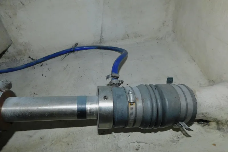 Slide: The Image of Engine room piping in a 1999 Michael Fitz Pilothouse boat, featuring blue hose and metal fittings. - 19
