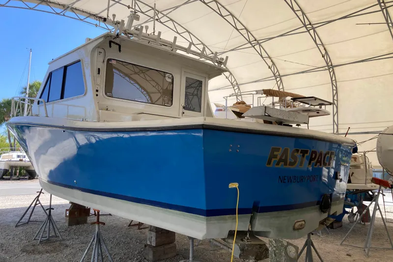 Slide: The Image of Blue 1999 Michael Fitz Pilothouse boat named "Fast Pace" in a covered storage area. - 4