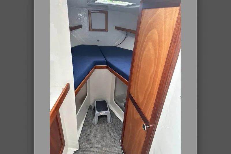 Slide: The Image of 1999 Michael Fitz Pilothouse interior with wooden door and blue-cushioned V-berth. - 13