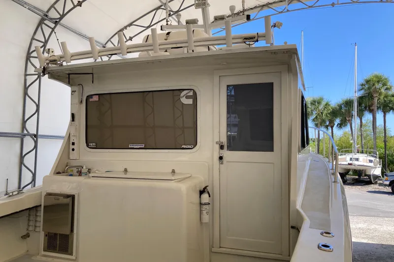 Slide: The Image of 1999 Michael Fitz Pilothouse boat under canopy with palm trees in background. - 5