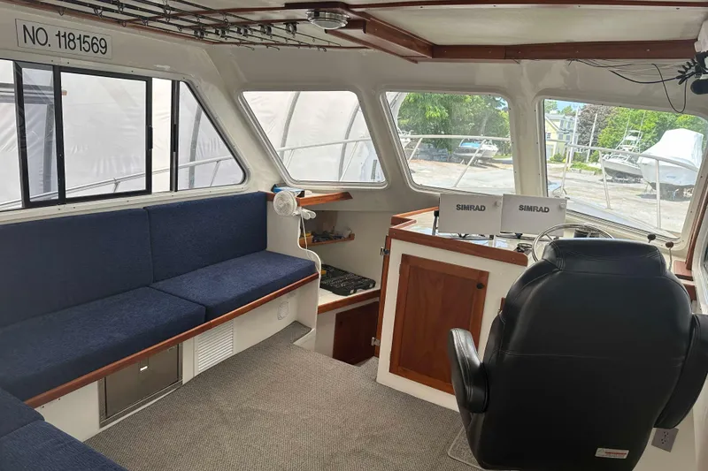 Slide: The Image of Interior of a 1999 Michael Fitz Pilothouse boat with seating and navigation equipment. - 6