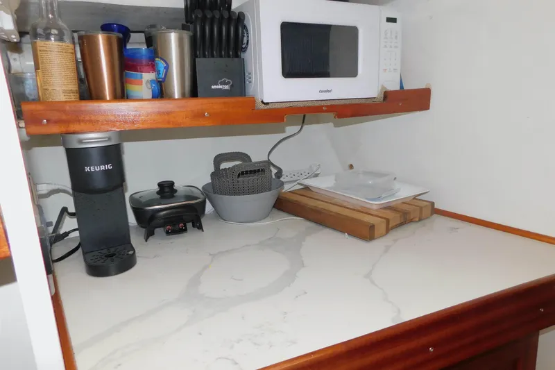 Slide: The Image of Small kitchen area with appliances and utensils on a Michael Fitz Pilothouse boat. - 11