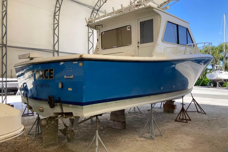 Slide: The Image of 1999 Michael Fitz Pilothouse boat on stands in a covered storage area. - 3
