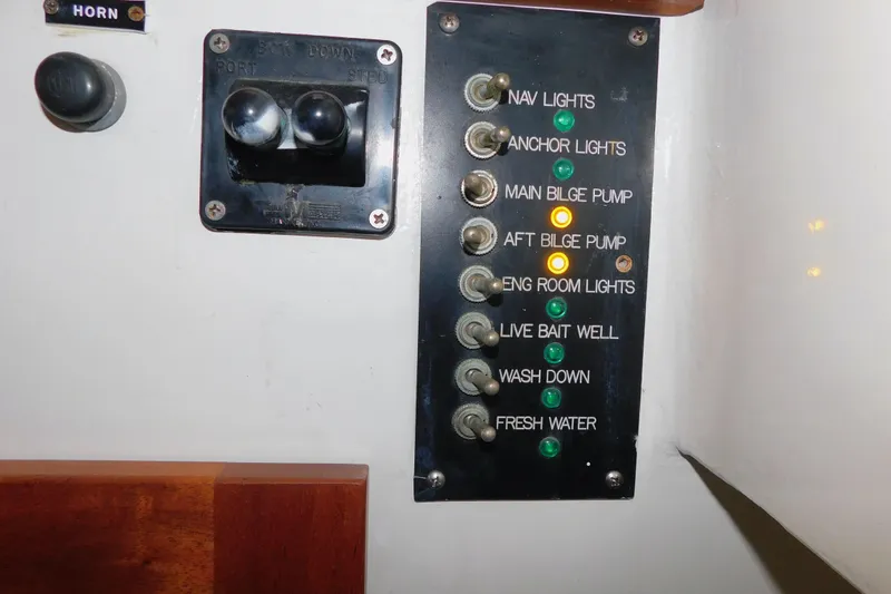 Slide: The Image of Control panel on a 1999 Michael Fitz Pilothouse boat with labeled switches and indicators. - 18
