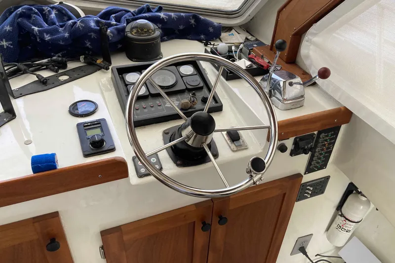 Slide: The Image of 1999 Michael Fitz Pilothouse helm with steering wheel, gauges, and controls. - 8