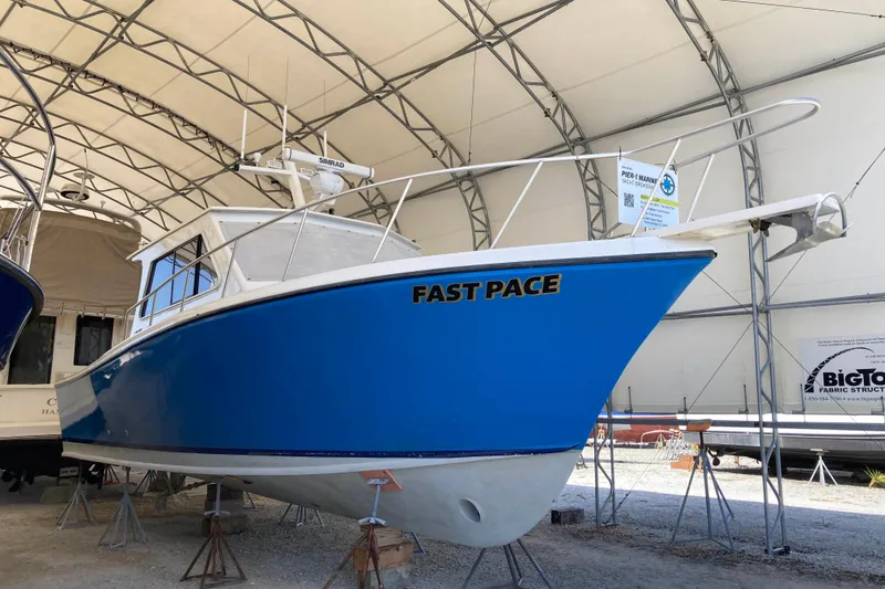 Slide: The Image of Blue 1999 Michael Fitz Pilothouse boat named "Fast Pace" in covered storage. - 2
