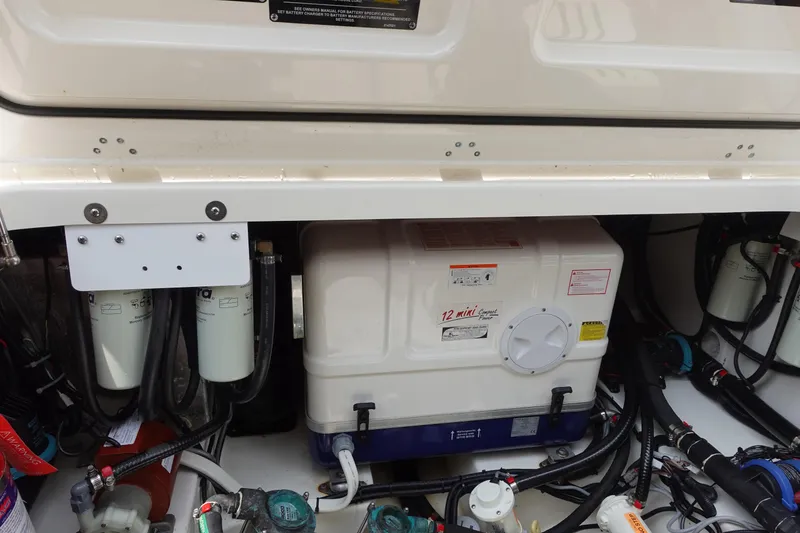 Slide: The Image of Engine compartment of a 2020 Boston Whaler 420 Outrage, showcasing filters and equipment. - 21