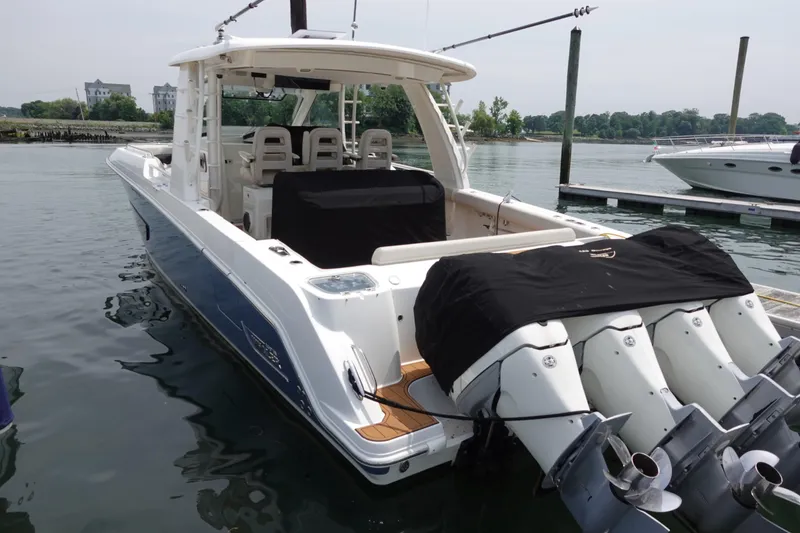 Slide: The Image of 2020 Boston Whaler 420 Outrage docked, featuring powerful outboard engines and sleek design. - 2