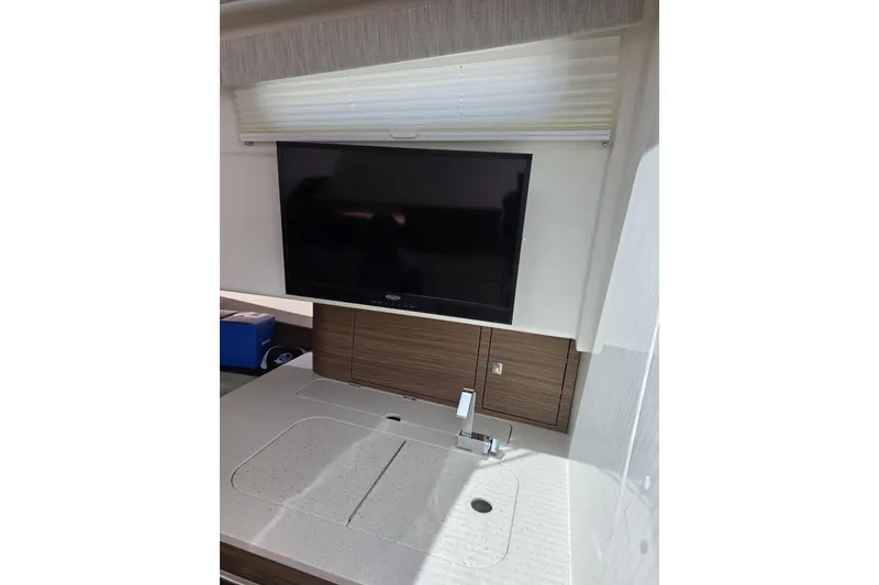 Slide: The Image of Interior of 2020 Boston Whaler 420 Outrage featuring a modern TV and sleek countertop. - 30