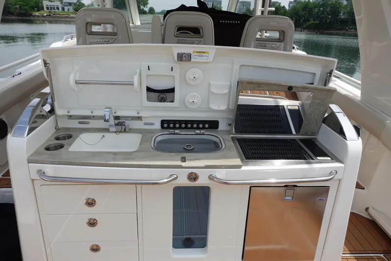 Slide: The Image of 2020 Boston Whaler 420 Outrage boat kitchen with sink, grill, and storage drawers. - 14
