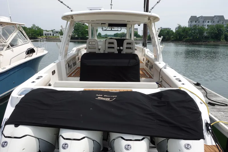 Slide: The Image of 2020 Boston Whaler 420 Outrage docked, showcasing spacious deck and covered engines. - 5