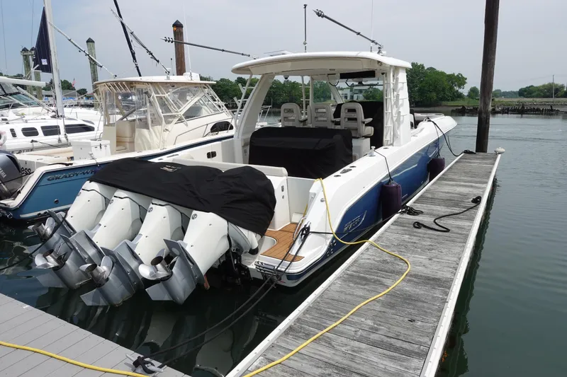 Slide: The Image of 2020 Boston Whaler 420 Outrage docked, featuring multiple outboard engines. - 4