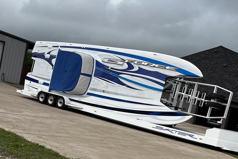 Slide: The Image of 2020 Skater 438 boat on trailer, featuring sleek blue and white design, parked outdoors. - 31