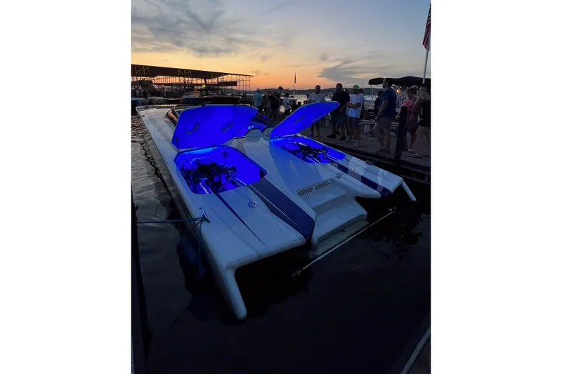 Slide: The Image of 2020 Skater 438 boat with blue-lit engine compartments at sunset dock gathering. - 36