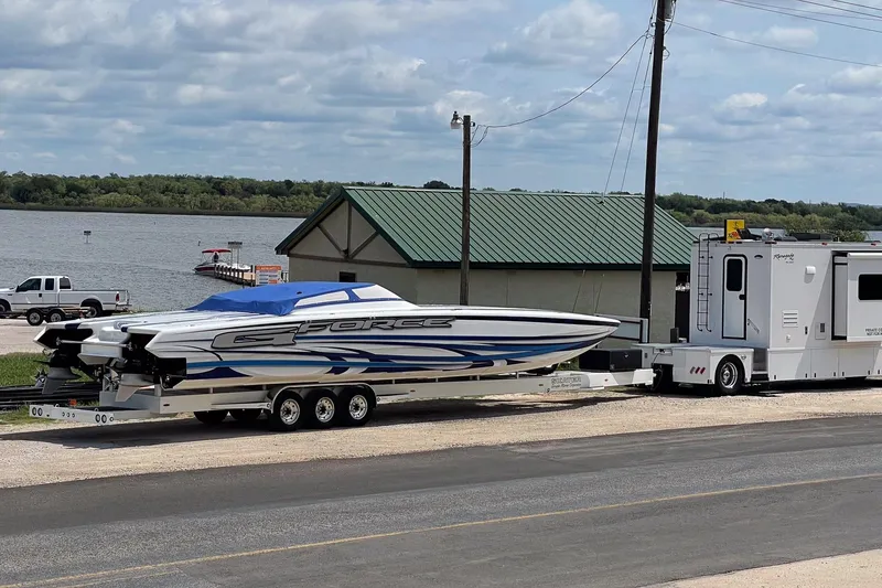 Slide: The Image of 2020 Skater 438 powerboat on trailer by lake, with RV nearby. - 30
