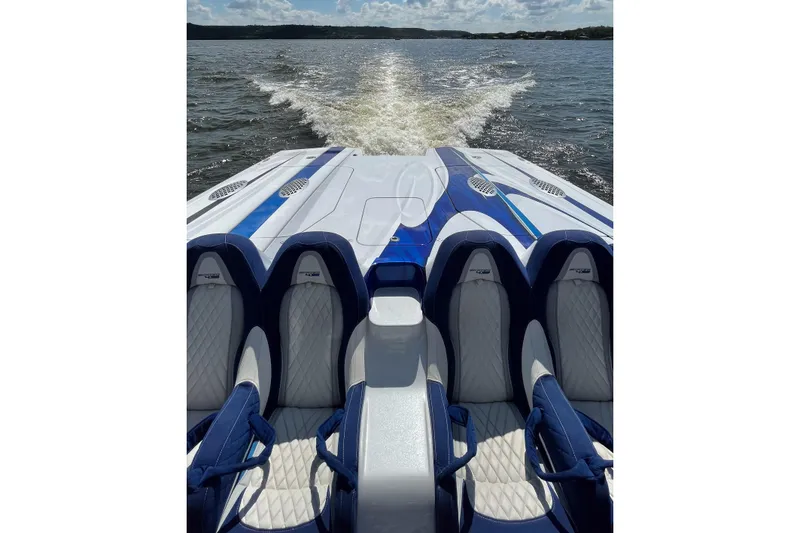 Slide: The Image of 2020 Skater 438 speedboat with blue and white seating, cruising on a sunny lake. - 19