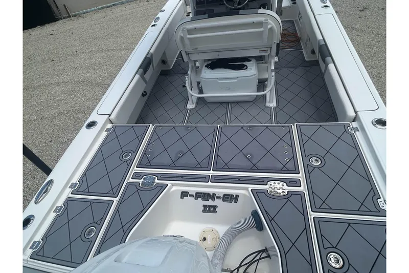 Slide: The Image of 2022 Robalo 266 Cayman boat interior with gray diamond-patterned deck and storage compartments. - 5