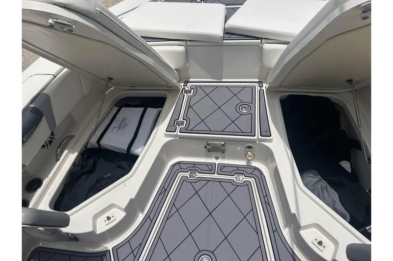 Slide: The Image of 2022 Robalo 266 Cayman boat storage compartments with open hatches and cushioned seating. - 18