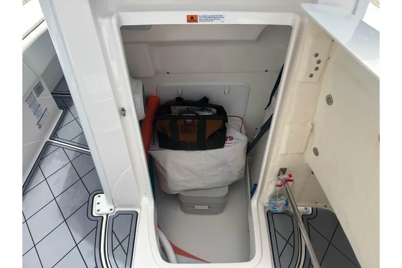 Slide: The Image of Storage compartment of 2022 Robalo 266 Cayman boat with gear and supplies. - 16