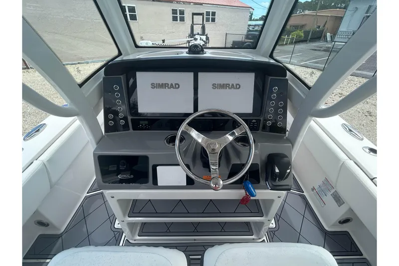 Slide: The Image of 2022 Robalo 266 Cayman boat helm with dual Simrad displays and modern steering wheel. - 6