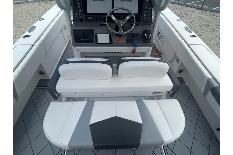 Slide: The Image of 2022 Robalo 266 Cayman boat interior with steering console and cushioned seating. - 7
