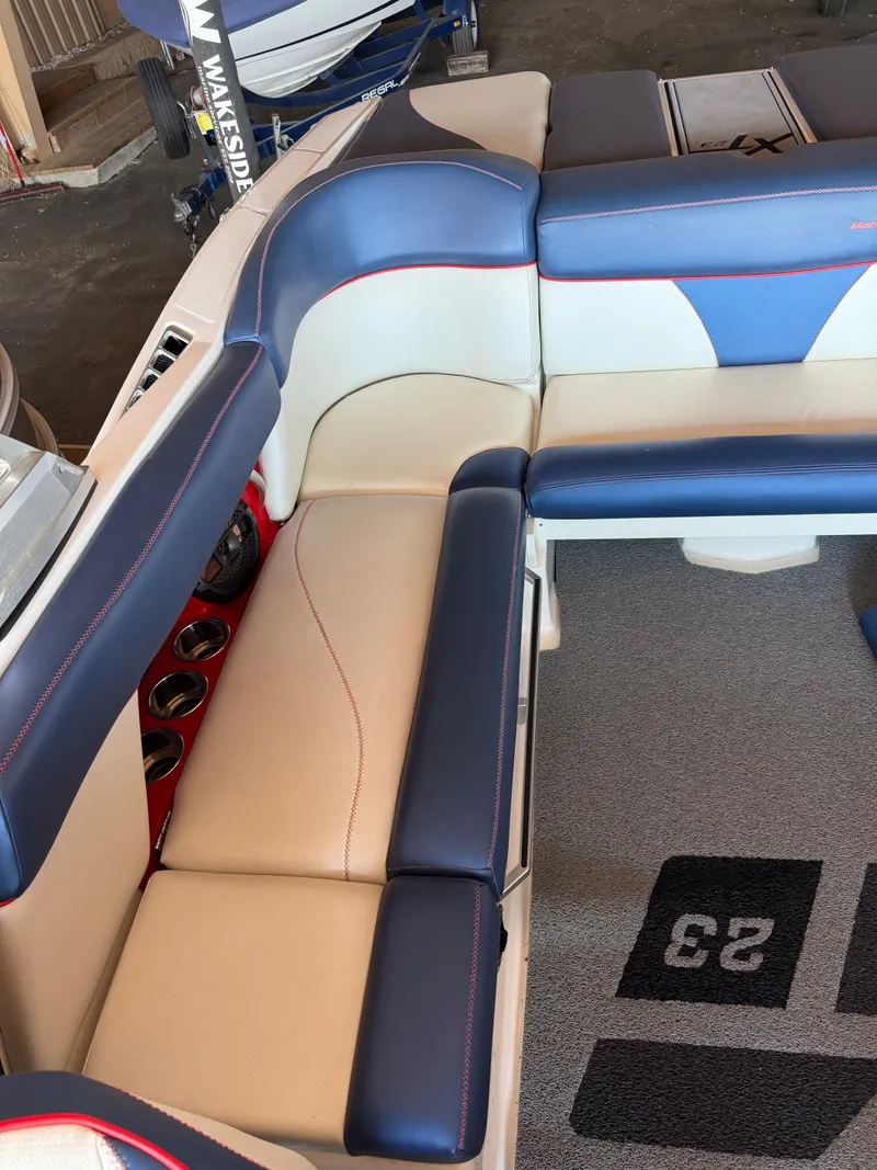 Slide: The Image of Interior of a 2018 MasterCraft XT23 with blue and white upholstery and carpeted flooring. - 3