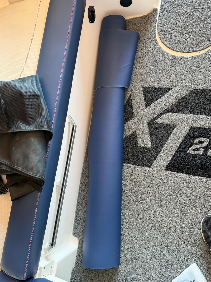 Slide: The Image of Interior of a 2018 MasterCraft XT23 with blue upholstery and carpet flooring. - 17