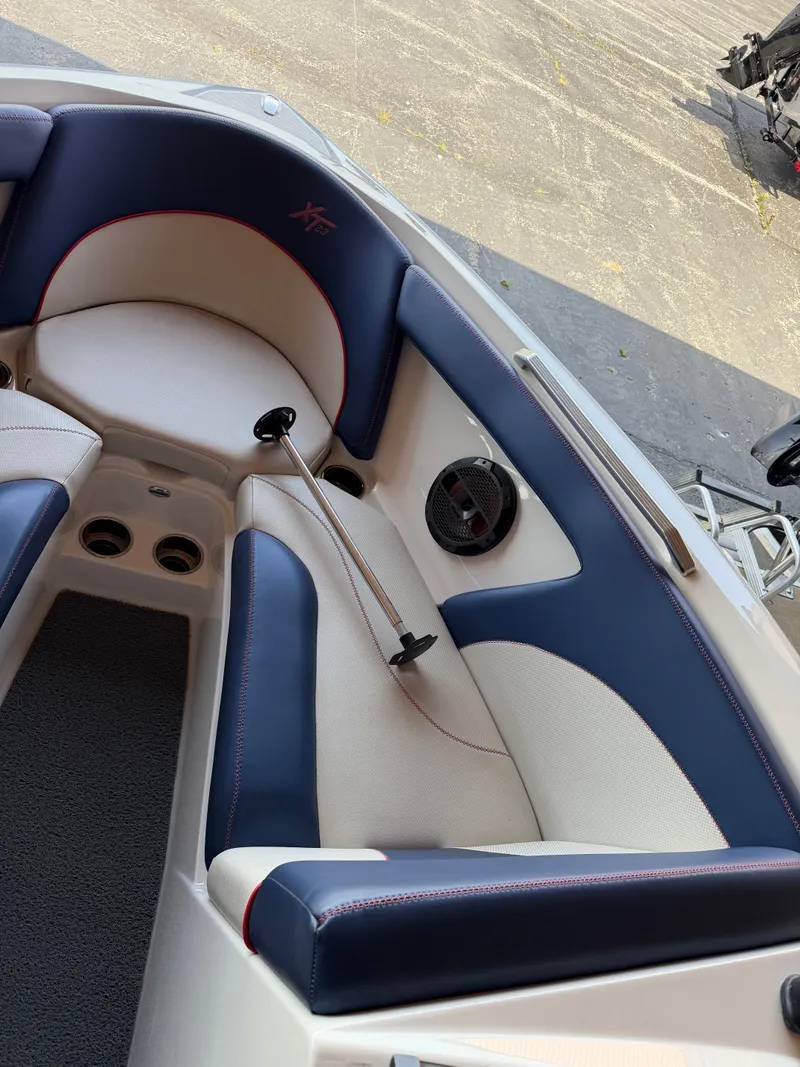 Slide: The Image of The image shows the interior of a 2018 MasterCraft XT23 boat with blue and white seating. - 12