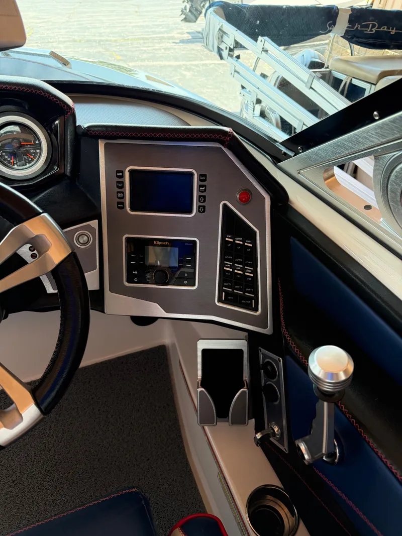 Slide: The Image of The cockpit of a 2018 MasterCraft XT23 with modern instruments and a sleek steering wheel. - 9