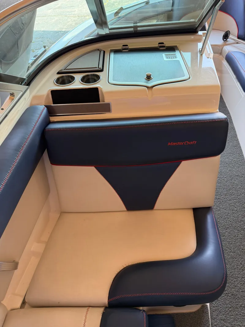 Slide: The Image of The interior of a 2018 MasterCraft XT23 features cushioned seating with blue and white accents. - 6