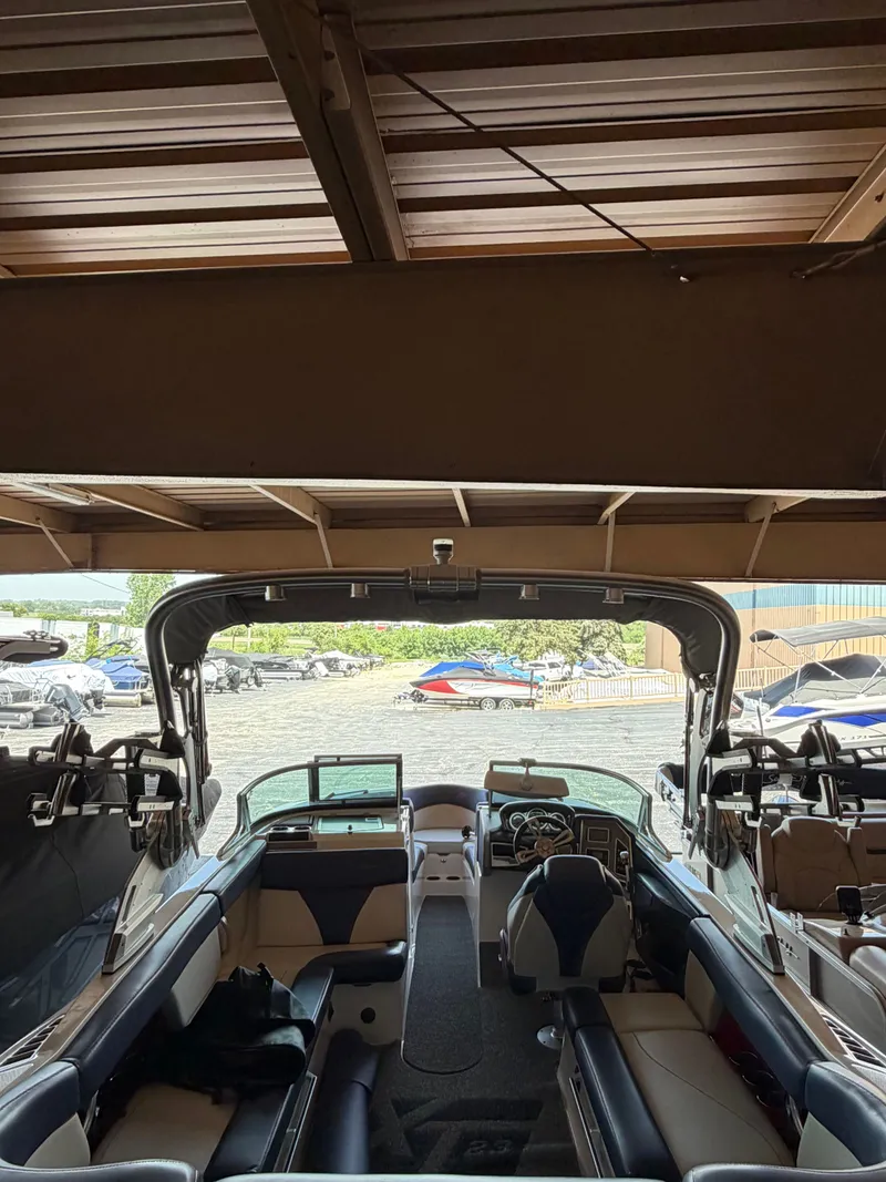 Slide: The Image of The image shows the interior of a 2018 MasterCraft XT23 boat inside a warehouse. - 13