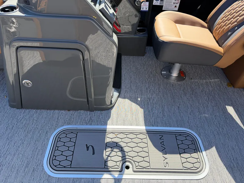 Slide: The Image of The image shows the interior of a 2027 Sylvan X1 LZ DH boat with gray flooring and a beige seat. - 15