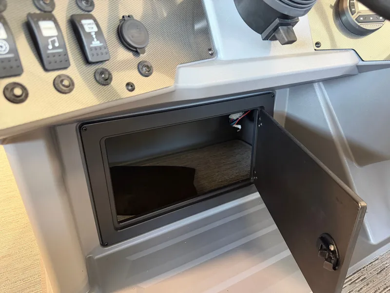 Slide: The Image of The image shows an open storage compartment on the dashboard of a Sylvan boat. - 15
