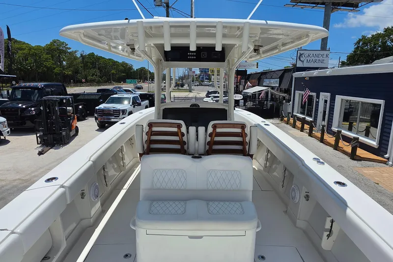 Slide: The Image of 2020 Jupiter 34 HFS boat interior with seating, parked at a marina dealership. - 9