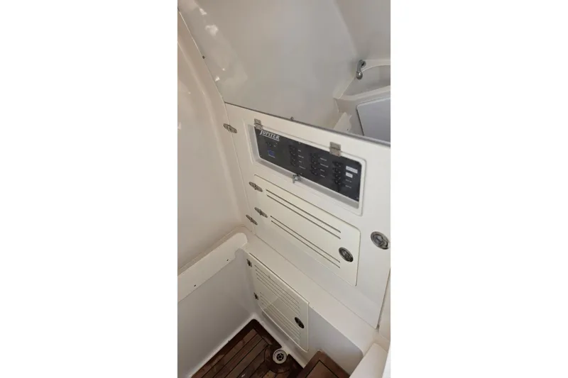 Slide: The Image of Control panel inside 2020 Jupiter 34 HFS boat, featuring switches and storage compartments. - 24