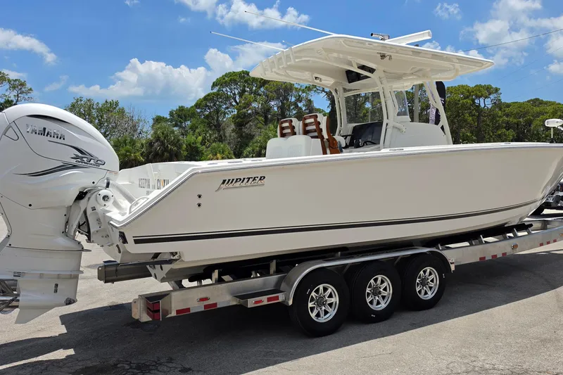 Slide: The Image of 2020 Jupiter 34 HFS boat on trailer with Yamaha engine, under clear blue sky. - 5