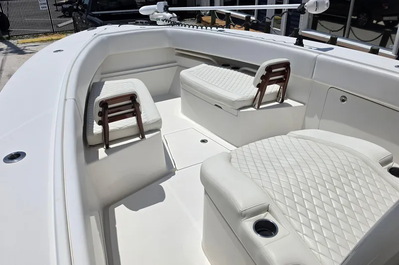 Slide: The Image of 2020 Jupiter 34 HFS boat interior with white quilted seating and cup holders. - 15
