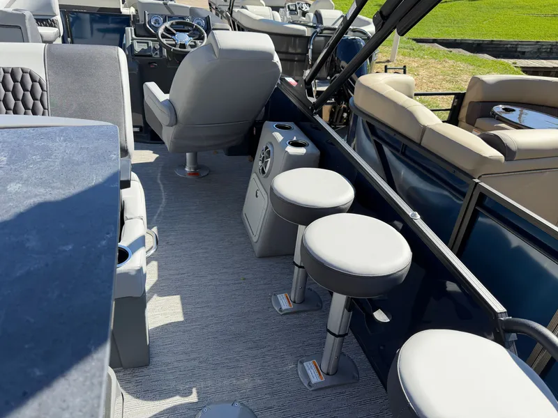 Slide: The Image of The image shows the interior of a 2027 Sylvan X5 DLZ DH BAR boat with seating and helm. - 25
