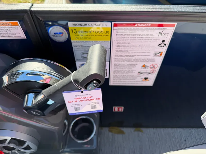 Slide: The Image of Close-up of the throttle lever on a 2027 Sylvan X5 DLZ DH BAR with safety and capacity notices. - 20