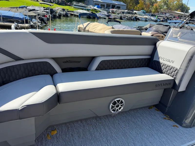 Slide: The Image of The image shows a modern boat seat with gray upholstery and Sylvan logo, surrounded by a marina. - 4