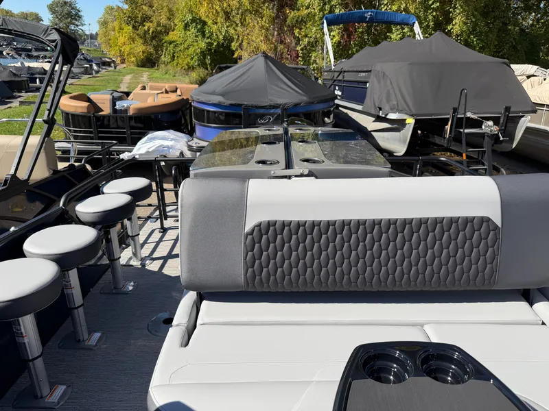Slide: The Image of The image shows the deck of a Sylvan X5 DLZ DH BAR boat with seating and bar stools. - 21