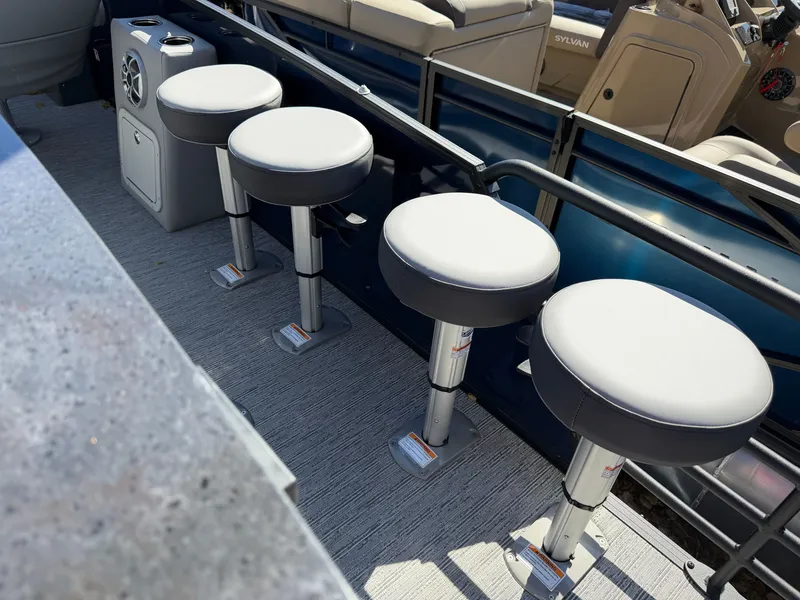 Slide: The Image of Four padded bar stools on a boat with gray flooring and blue accents. - 22