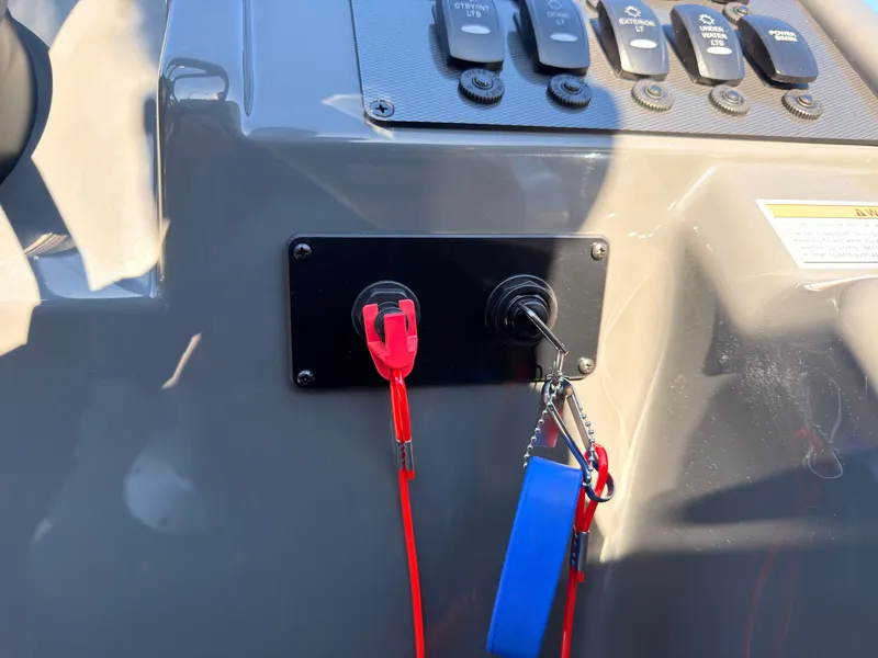 Slide: The Image of Close-up of a boat control panel with switches and a safety lanyard. - 44