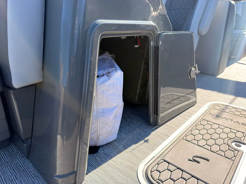 Slide: The Image of An open storage compartment on a 2027 Sylvan X3 LZ DH boat with a bag inside. - 29