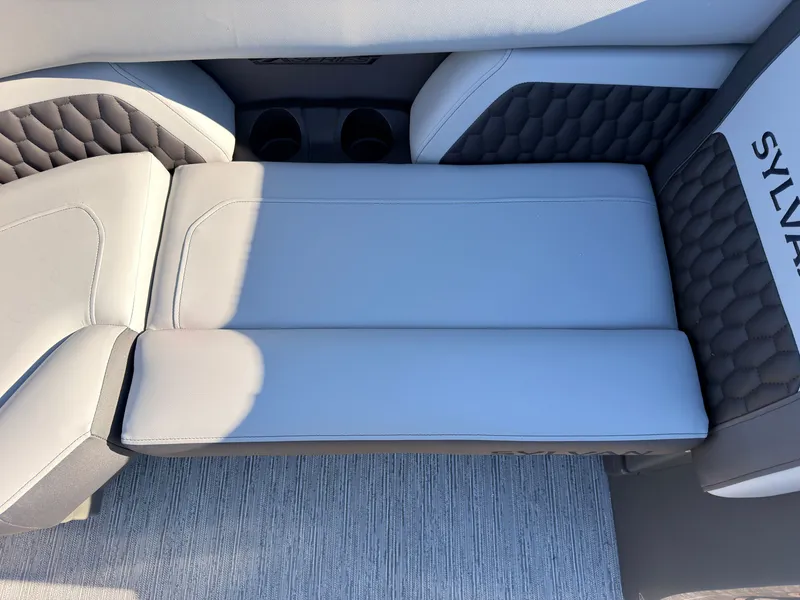 Slide: The Image of The 2027 Sylvan X3 LZ DH features sleek gray upholstery with a honeycomb pattern and cup holders. - 22