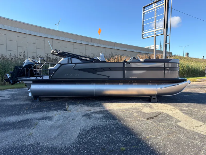 Slide: The Image of A modern Sylvan X3 LZ DH pontoon boat from 2027 is parked on a lot. - 2