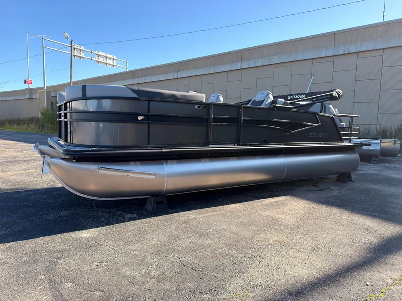 Slide: The Image of A modern pontoon boat with a black hull and silver accents sits in a parking lot. - 7